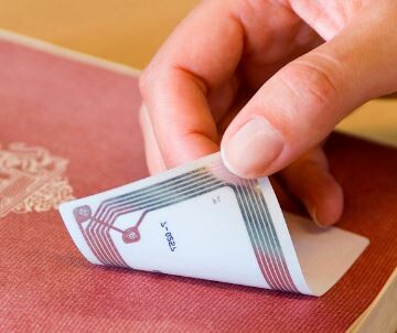 An RFID tag being put on a book. 